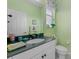 Charming bathroom with green walls, flamingo accents, and a well-lit vanity at 4423 Via Del Villetti Dr, Venice, FL 34293