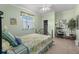 Inviting bedroom featuring a comfortable bed, rocking chair, and serene, light green walls at 4423 Via Del Villetti Dr, Venice, FL 34293