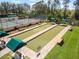 View of bocce ball court and tennis court with benches and green canopies at 4423 Via Del Villetti Dr, Venice, FL 34293