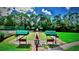 Bocce ball court with green canopies and benches in landscaped community at 4423 Via Del Villetti Dr, Venice, FL 34293