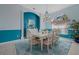 Dining room with bright blue accent wall, stylish furnishings, and large windows at 4423 Via Del Villetti Dr, Venice, FL 34293