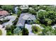 Aerial view of a beautiful home with a gray roof, lovely landscaping, and a circular driveway at 4815 Featherbed Ln, Siesta Key, FL 34242