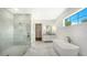 Bathroom with a marble walk-in shower, soaking tub, and bright natural light from a window at 4815 Featherbed Ln, Siesta Key, FL 34242