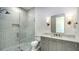 Bathroom featuring white tiled shower, marble countertop vanity, and decorative sconces at 4815 Featherbed Ln, Siesta Key, FL 34242