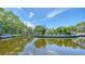Beautiful waterfront property with lush landscaping and serene water views on a bright sunny day at 4815 Featherbed Ln, Siesta Key, FL 34242