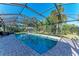 Sparkling pool enclosed in a screened lanai, surrounded by lush landscaping at 5003 86Th Street W Ct, Bradenton, FL 34210