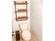 Small bathroom with floating shelves, toilet and a bronze waste bin at 5311 Creek Dr, Sarasota, FL 34231