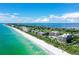 Beautiful aerial view of beachfront condominiums with pristine white sand and turquoise water at 575 Sanctuary Dr # A303, Longboat Key, FL 34228