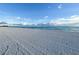 Beautiful beach view with white sand and turquoise water under a blue sky with scattered clouds at 575 Sanctuary Dr # A303, Longboat Key, FL 34228