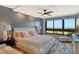 Spacious bedroom with wood-look floors, a ceiling fan, and large windows at 575 Sanctuary Dr # A303, Longboat Key, FL 34228
