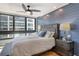 Well-lit bedroom featuring a plush bed, ceiling fan, and large windows with scenic outdoor views at 575 Sanctuary Dr # A303, Longboat Key, FL 34228