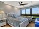 Bright bedroom featuring a plush bed, ceiling fan, and large windows with scenic outdoor views at 575 Sanctuary Dr # A303, Longboat Key, FL 34228