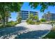 Building exterior with a circular driveway and landscaping at 575 Sanctuary Dr # A303, Longboat Key, FL 34228