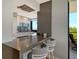 Modern kitchen featuring a breakfast bar and views of the adjacent balcony at 575 Sanctuary Dr # A303, Longboat Key, FL 34228
