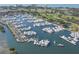 Scenic aerial view of a marina filled with numerous boats and yachts, set against a golf course backdrop at 575 Sanctuary Dr # A303, Longboat Key, FL 34228