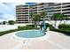 Relaxing community spa pool surrounded by lush landscaping and a comfortable seating area at 575 Sanctuary Dr # A303, Longboat Key, FL 34228