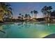 Tranquil nighttime view of the community pool reflecting the surrounding palms at 575 Sanctuary Dr # A303, Longboat Key, FL 34228