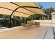 Outdoor dining area featuring a covered patio with tables and chairs near the pool, perfect for entertaining at 575 Sanctuary Dr # A303, Longboat Key, FL 34228