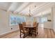 Dining room with white wood beams, four chairs around a wooden table, and hardwood flooring at 640 Venice Ln, Sarasota, FL 34242