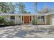 Stately front door with stone accents, well maintained landscaping, and large concrete driveway at 640 Venice Ln, Sarasota, FL 34242