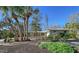 Charming single-story home with a well-manicured lawn and mature trees, showcasing its curb appeal at 640 Venice Ln, Sarasota, FL 34242