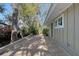 Side view of home featuring a stone patio and adjacent greenery at 640 Venice Ln, Sarasota, FL 34242