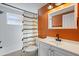 Updated bathroom with white vanity, an orange accent wall, and black fixtures at 7720 Judith Cres, Port Richey, FL 34668