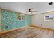 Bedroom with tropical print wall and wood-look floors at 7720 Judith Cres, Port Richey, FL 34668