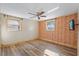 Bedroom with light wood flooring, an orange accent wall, and two windows at 7720 Judith Cres, Port Richey, FL 34668