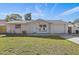 House exterior featuring a white brick facade, attached garage, and well-maintained lawn at 7720 Judith Cres, Port Richey, FL 34668