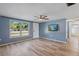 Living room featuring light wood floors, blue walls, and a window at 7720 Judith Cres, Port Richey, FL 34668