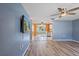 Living room with light wood floors, blue walls, and a view into the kitchen at 7720 Judith Cres, Port Richey, FL 34668