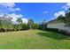 Large manicured backyard with mature landscaping and partial view of house with screened-in patio at 931 Mangrove Edge Ct, Bradenton, FL 34208