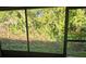 View of backyard through screened enclosure at 1313 54Th E Ave # 1313, Bradenton, FL 34203