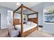 Main bedroom with a wooden canopy bed and ensuite bathroom at 13930 Old Creek Ct, Parrish, FL 34219