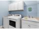 Laundry room with washer, dryer, cabinets, and utility sink at 13930 Old Creek Ct, Parrish, FL 34219
