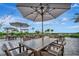 Relaxing outdoor patio area with tables, umbrellas, string lights, and lush landscaping at 15415 Derna Ter, Bradenton, FL 34211