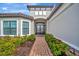 Front entry with brick walkway, lush landscaping, and a double door entry at 15415 Derna Ter, Bradenton, FL 34211