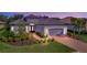 Exterior of a single-story home with a gray garage door and landscaped yard at 15415 Derna Ter, Bradenton, FL 34211