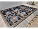Close-up view of six-burner gas cooktop with lit blue flames at 15415 Derna Ter, Bradenton, FL 34211