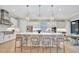 Modern white kitchen with large island, stainless steel appliances, and pendant lighting at 15415 Derna Ter, Bradenton, FL 34211