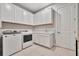 Bright laundry room with white cabinets, washer, and dryer at 15415 Derna Ter, Bradenton, FL 34211