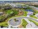 A high angle view of a gray home surrounded by a luxurious lawn, pond, and manicured trees at 15815 Tradewind Ter, Bradenton, FL 34211