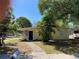 Charming single story home with a lush tropical front yard and a welcoming blue front door at 1630 29Th St, Sarasota, FL 34234