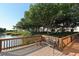 Wooden deck with bench and table, overlooking tranquil water at 1801 Gulf N Dr # 256, Bradenton Beach, FL 34217