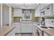 White kitchen with appliances and window overlooking trees at 2771 Golf Course Dr # 101, Sarasota, FL 34234