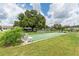 Community shuffleboard court with benches under a large tree at 2771 Golf Course Dr # 101, Sarasota, FL 34234