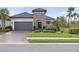 Charming single-Gathering home featuring a stone facade, gray garage door, and lush landscaping at 4708 Trento Pl, Bradenton, FL 34211