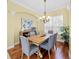 Warm dining room with wood floors, an elegant chandelier, and neutral wall color at 518 Luminary Blvd, Osprey, FL 34229