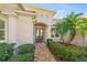 Inviting front entrance featuring a tiled walkway, decorative glass doors, and mature landscaping at 518 Luminary Blvd, Osprey, FL 34229